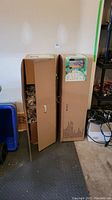 Two tall boxes containing the porch trees, showing unopened and partially opened packaging.