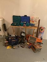 Wide view of the lot showing toolboxes, heaters, lights, books, and other items assembled on floor and tables.