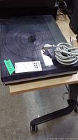 Overall view of turntable with dust cover closed and coiled power cable on top