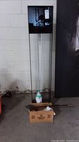 Overall view of tall lucite floor clock with black metal top housing, clear acrylic sides and pendulum area.