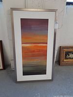 Framed vertical abstract painting showing full view with background and surrounding items.