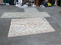Two knit rugs displayed on the floor showing overall appearance and size difference.