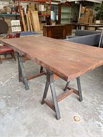 Front view of table showing wood top and sawhorse legs