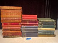 Photo showing the full collection of 32 books stacked in three columns, displaying varied colors and sizes.