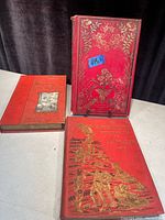 Three red antique French books with gilt detailing on covers, shown front and spine.