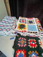Image showing three crochet handmade blankets folded together with different colorful patterns.