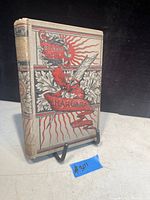 Front cover of antique book The Ingoldsby Legends with decorative red and black design, titled 'Harvard' with copyright date 1890, showing spine and worn edges.