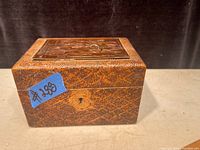 Front and side view of antique Flemish wooden tea caddy showing textured wood grain and keyhole.