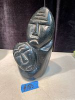 Front view of the vintage Inuit stone carving sculpture showing two carved faces.