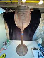 Front view of vintage all metal plant stand showing wire mesh basket and circular base