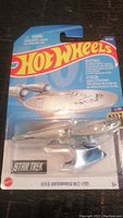 Front view of Hot Wheels Star Trek USS Enterprise NCC-1701 die-cast vehicle sealed in original blister packaging showing model and branding.