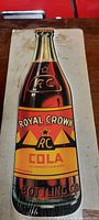 Full view of the Royal Crown Cola shaped bottle sign showing brand logo and retro graphic design.