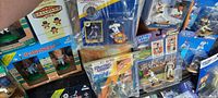 Overview of the collection laid out showing various sports collectible figurines and bobbleheads in original boxes, some stacked and some flat.