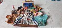 Full lot overview showing antique toys and figures including vehicles, puppets, and military/western figures arranged on a white table.