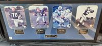 Full view of framed 30" x 12" Baltimore Colts football player wall sign showing four players with plaques.