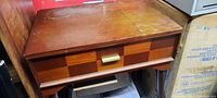 Vintage Singer sewing machine cabinet front and top view showing drawer with brass handle and wood finish.