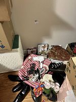 Photo showing assorted ladies accessories including purses, scarves, black shoes size 9, black hat, and a Conair hair dryer laid out on the floor.