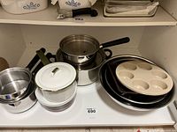 Set of pots, pans, muffin pan, and baking sheets in shelf space