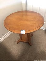 Top view of round maple side table showing the smooth surface with visible scratches and wear marks.