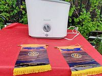 Photo of white Honeywell humidifier on red surface with rotary knob and power switch on front, two banners nearby