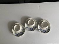 Top view of three Figgjo Flint Lotte ceramic eggcups showing blue floral pattern around the edges on a white background.