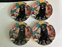 Top view showing all four plates with black Labrador dog and floral background design.