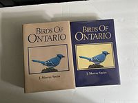 Front covers of Birds of Ontario Volumes 1 and 2, showing blue jay illustration and author name J. Murray Speirs on the covers with dust jackets.