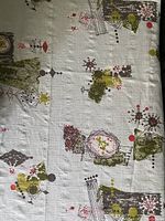 Photo showing abstract mid-century pattern on light blue/grey cotton fabric with green, red, and gray geometric shapes.