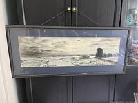 Full view of framed panoramic photo showing icy terrain and structure