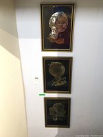 Overview of all three vertically aligned framed pictures of hot air balloons mounted on a wall