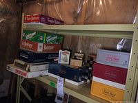 Shelf with stacked vintage board games including Yahtzee, Triple Yahtzee, Backgammon, Monopoly, and chess boards