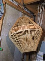 Wicker hanging lamp suspended, showing full exterior shape and design.