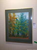Forest print hanging on wall, gold frame with green double mat around birch tree scene
