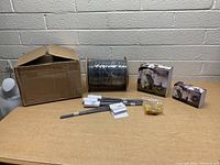 Full lot displayed on table showing box, wire spool, stakes, and hardware bag