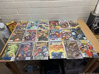Photo showing the entire set of 18 comic books spread out on a table, various titles visible including Batman, Superman, Star Trek, Captain America