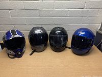 All four helmets lined up showing front and side views with colors and logos visible