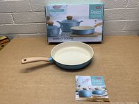Front angle photo of the 11 inch frying pan with packaging box in background.