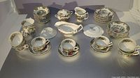 Overview of all 51 pieces including cups, saucers, plates, creamer, sugar set, and gravy boat showing the full collection and pattern.