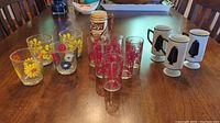 Full lot view showing all 14 vintage glassware items on wooden table.