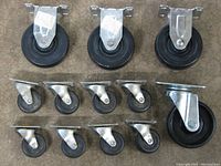 Group photo showing all 12 casters with three large casters, one medium large swivel caster, and eight smaller swivel casters.