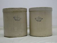 Front view of two stoneware crocks with Crown logo stamps visible.