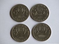 Top view of the reverse side of four Canadian dollar coins showing the Voyager canoe design with dates 1977, 1978, 1979, and 1980.