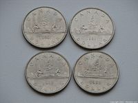 Four Canadian one dollar coins arranged in a square, reverse side facing up showing the Voyager canoe design dated 1980, 1981, 1982, and 1983.