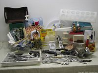 Full assortment shot of all kitchen and related items on a table showing cutlery, utensils, containers, and kitchen tool variety