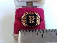 Front view showing ring inside box with ruler for scale.