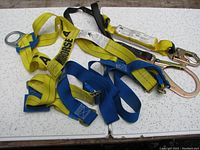 Full view of Workhorse safety harness with visible brand name and attached 3M shock lanyard, showing yellow and blue webbing, metal rings and hooks.