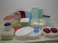 Photo showing full lot of containers including Divide-A-Rack pie stackers, Tupperware midget, and assorted storage containers in multiple colors and sizes