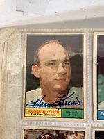 Close-up photo of signed Harmon Killebrew baseball card showing player portrait and signature in blue ink.