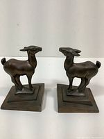 Pair of brass doe bookends side view, showing stylized deer on tiered square bases.