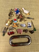 Overview of various enamel charms including animals, musical note brooch, miniature items, and decorative buckle